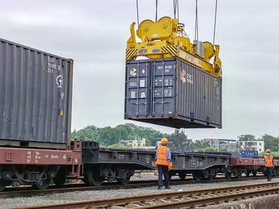 圖為一線作業人員指揮龍門吊正在把裝有鋅精礦的集裝箱放在車上(潘麗蓉 攝) (2).jpg